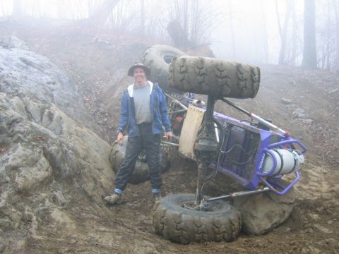 1992 Ford Mustang - A person stands next to an overturned off-road buggy in a muddy, foggy environment.