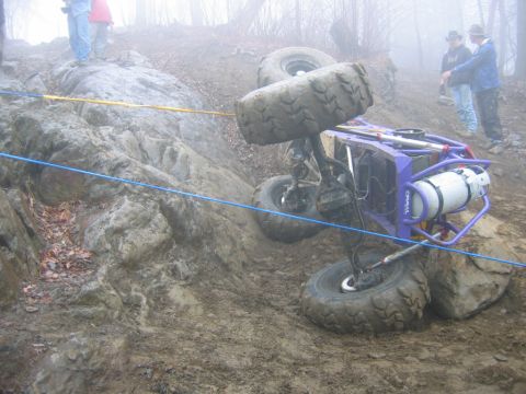 1992 Ford Mustang - An off-road buggy is seen tipped on its side during an event, with a propane tank visible on its frame.