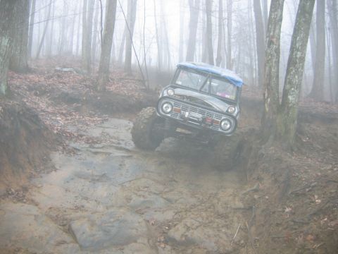 1992 Ford Mustang - Modified Ford Bronco navigating a challenging off-road course in foggy conditions.