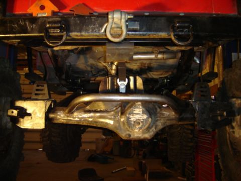 1992 Ford Bronco - Undercarriage view of a heavily modified off-road vehicle, focusing on the rear axle and suspension components.
