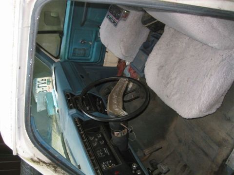 1978 Ford Bronco - A view inside a vehicle shows fuzzy seat covers and a license plate, with the dashboard and steering wheel visible.