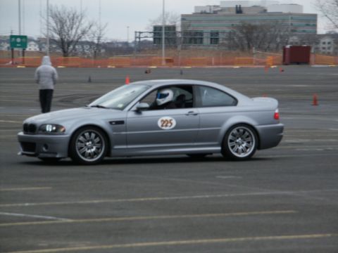 2001 Mercury Grand Marquis - A silver coupe with racing number 225 on the door is seen on a track with a driver wearing a helmet.