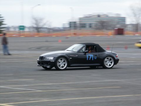 2001 Mercury Grand Marquis - A black convertible sports car with racing numbers navigates a track during an event.