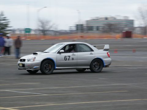 2001 Mercury Grand Marquis - Silver Subaru Impreza WRX STI sedan with racing number 67 B on the door is seen on a track.