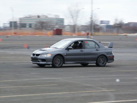 2001 Mercury Grand Marquis - A gray Mitsubishi Lancer Evolution VIII is seen on a paved track with orange cones in the background.