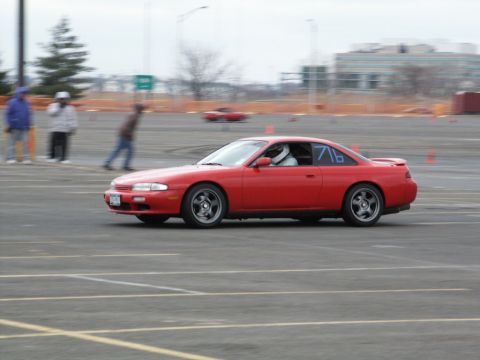 2001 Mercury Grand Marquis - A red Nissan 240SX coupe is seen on a track, with a driver wearing a helmet and the number 716 displayed on the side.
