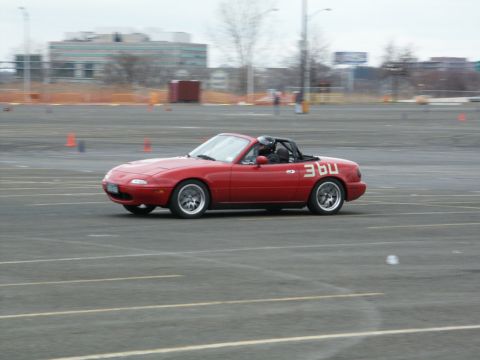 2001 Mercury Grand Marquis - A red convertible sports car with racing numbers is seen on a track during what appears to be a timed event.