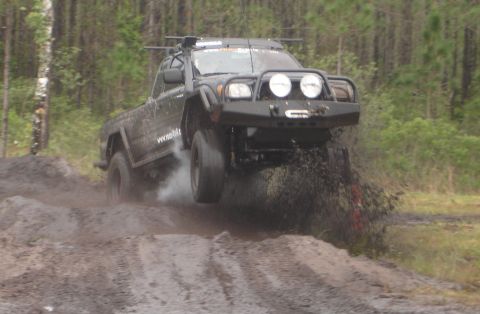 1989 Ford Bronco - This modified pickup truck is captured mid-air while navigating a challenging off-road course.