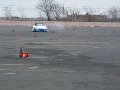 2001 Mercury Grand Marquis - A two-tone convertible sports car is seen on a track, maneuvering around orange cones.