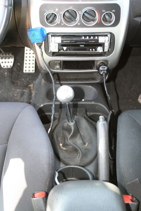 1996 Ford Probe - Interior view of a car's center console, a manual gear shifter and aftermarket stereo system.