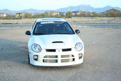 1996 Ford Probe - This white Dodge Neon SRT-4 features a prominent hood scoop and a Mopar emblem on the front grille.