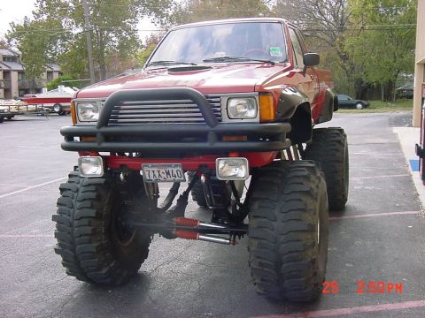 1993 Ford Bronco - This modified pickup truck features oversized tires and a prominent front brush guard.