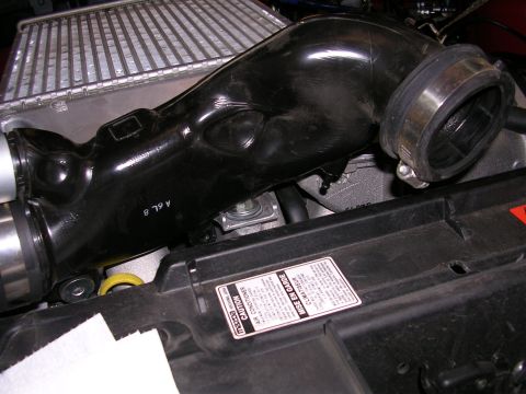 2007 Mazda 3 - Close-up of the engine bay of a 2007 Mazda 3, showing the intake pipe and radiator.