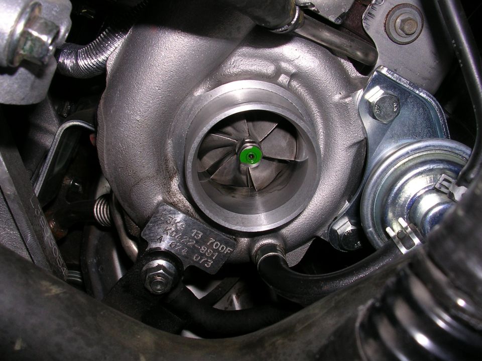 Close-up of a turbocharger with visible part numbers on a metal tag