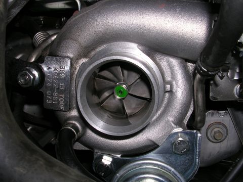 2007 Mazda 3 - A turbocharger with a metal tag showing part numbers and markings.