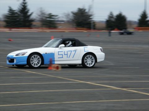 2001 Mercury Grand Marquis - A white convertible with blue racing stripes and the number 5477 is seen on a race track.