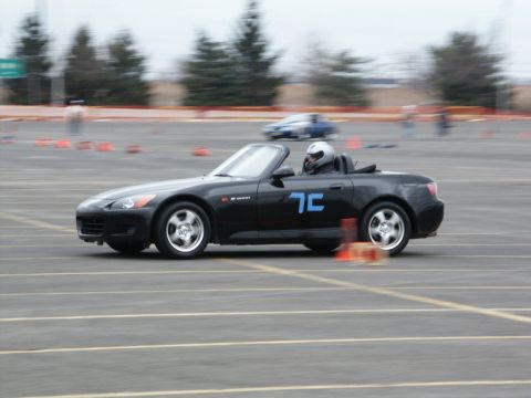 2001 Mercury Grand Marquis - A black convertible sports car is seen on a track, possibly during a timed event or race.
