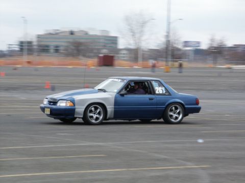 2001 Mercury Grand Marquis - A two-tone Ford Mustang competes in a race, with the number 26s visible on its side.