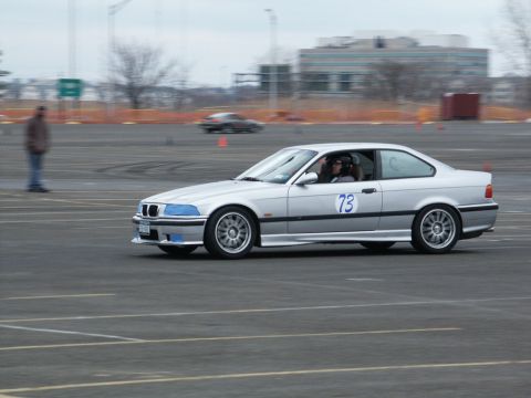 2001 Mercury Grand Marquis - A silver coupe with racing number 73 is seen on a track, with another car blurred in the background.