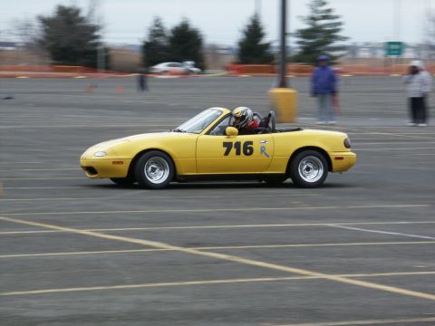 2001 Mercury Grand Marquis - Yellow convertible sports car with racing number 716 on the door is seen on a track.