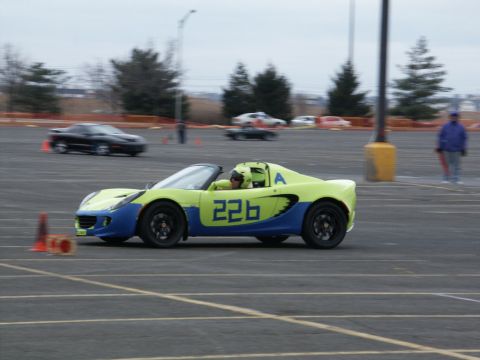2001 Mercury Grand Marquis - A lime green and blue sports car with the number 226 on its side navigates a course, with other vehicles blurred in the background.
