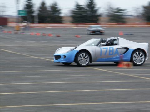 2001 Mercury Grand Marquis - Lotus Elise convertible participating in an event on a paved track, with another vehicle visible in the distance.