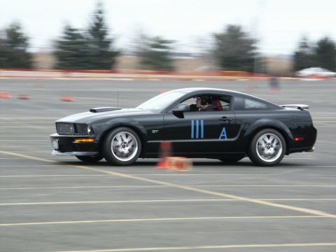 2001 Mercury Grand Marquis - A black Ford Mustang is seen on a track, marked with racing numbers and stripes.