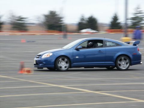 2001 Mercury Grand Marquis - A blue coupe navigates a course marked by orange cones, with racing numbers visible on its side.
