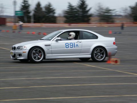 2001 Mercury Grand Marquis - A silver BMW M3 E46 navigates a course with orange cones, driver in a helmet visible.