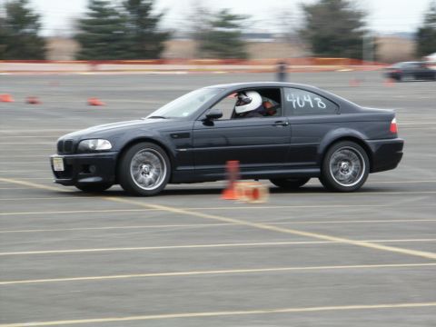 2001 Mercury Grand Marquis - A black coupe with racing number 4048 is captured in motion on a race track, navigating around orange cones.