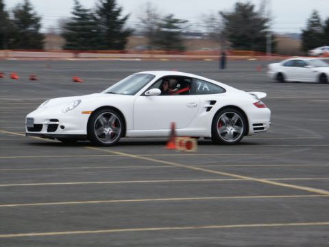 2001 Mercury Grand Marquis - A white Porsche 911 navigates a course marked by cones, with another car visible in the background.
