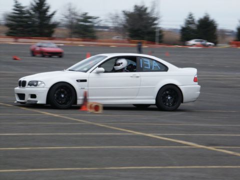 2001 Mercury Grand Marquis - A white coupe with racing numbers participates in a track event, with another car blurred in the background.