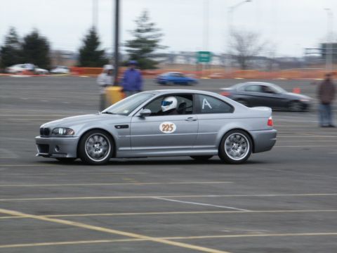2001 Mercury Grand Marquis - Silver BMW M3 coupe with racing numbers on track, another car in background.