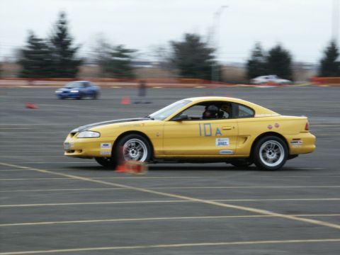 2001 Mercury Grand Marquis - A yellow coupe with racing decals navigates a track with orange cones visible.