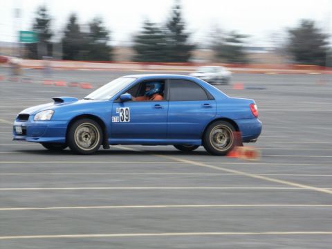 2001 Mercury Grand Marquis - A blue Subaru Impreza WRX STI sedan, number 39, navigates a race track with cones visible.