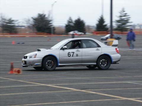 2001 Mercury Grand Marquis - Silver Subaru WRX STI sedan with racing number 67 B on the door, participating in a race event.