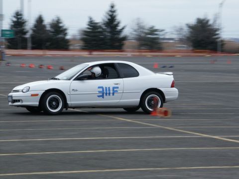 2001 Mercury Grand Marquis - White Dodge Neon coupe navigates a race track course with orange cones visible.