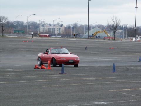 2001 Mercury Grand Marquis - A red convertible navigates a cone course in a large, paved area.