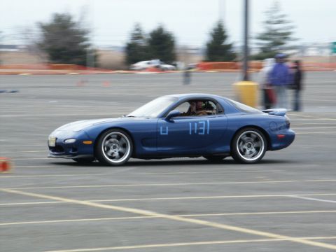 2001 Mercury Grand Marquis - Blue Mazda RX-7 (FD generation) participates in a track event, displaying racing numbers on its side.