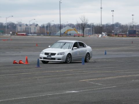 2001 Mercury Grand Marquis - A silver sedan navigates a course marked by traffic cones on a cloudy day.