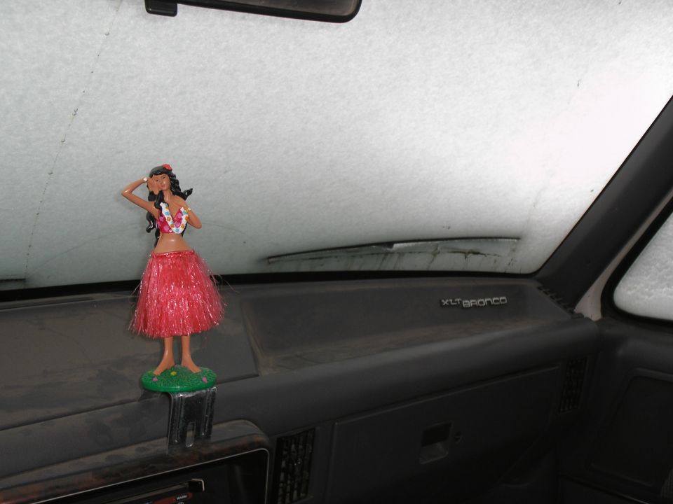 Dashboard of a vehicle with a hula dancer figurine and 'XLT BRONCO' text on the dash