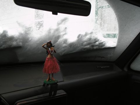 1990 Ford Bronco - A hula dancer figurine sits on the dashboard of a 1990 Ford Bronco, looking out at a snow-covered windshield.