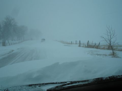 1990 Ford Bronco - Driving through heavy snow with poor visibility on a rural road.