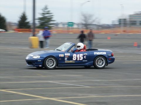 2001 Mercury Grand Marquis - A blue Mazda Miata convertible is seen on a race track with racing decals and number 815 displayed.