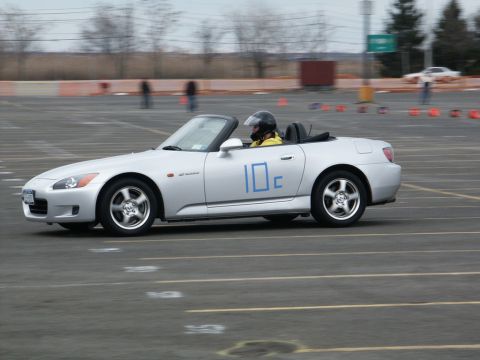 2001 Mercury Grand Marquis - A silver convertible sports car with the number 10c on its side navigates a track, driven by a helmeted individual.