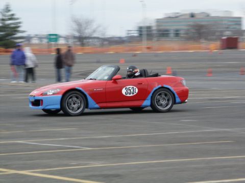 2001 Mercury Grand Marquis - A red convertible sports car with blue accents and racing number 353 is seen on a race track.