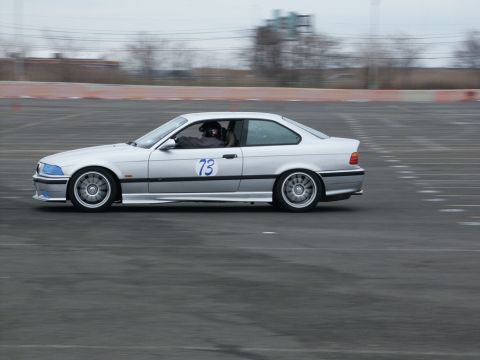 2001 Mercury Grand Marquis - A silver coupe with racing number 73 is seen on a track, likely during a performance driving event.
