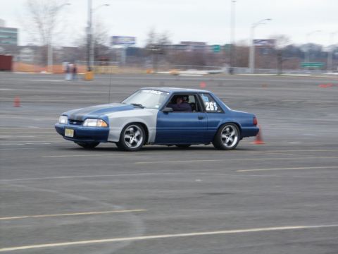 2001 Mercury Grand Marquis - A two-tone Ford Mustang with racing decals navigates a course marked by orange cones.