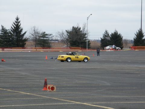 2001 Mercury Grand Marquis - A yellow convertible sports car, identified by the number 716, navigates a course marked by cones on a cloudy day.