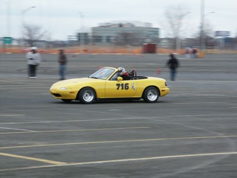 2001 Mercury Grand Marquis - Yellow convertible sports car with racing number 716 on its door is seen on a track.